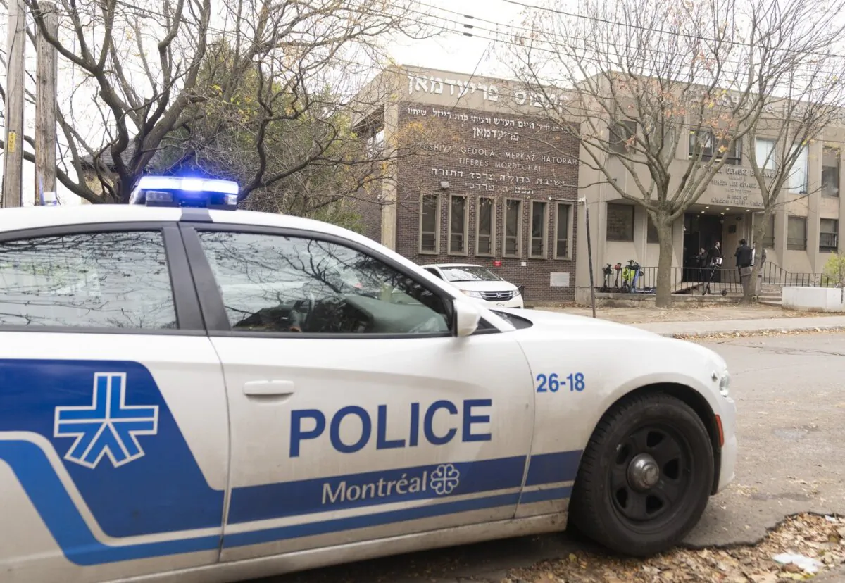 A police vehicle sits outside the Yeshiva Gedola, a Jewish school that was hit by gunshots for the second time in three days, in Montreal, on Nov. 13, 2023. (The Canadian Press/Christinne Muschi)