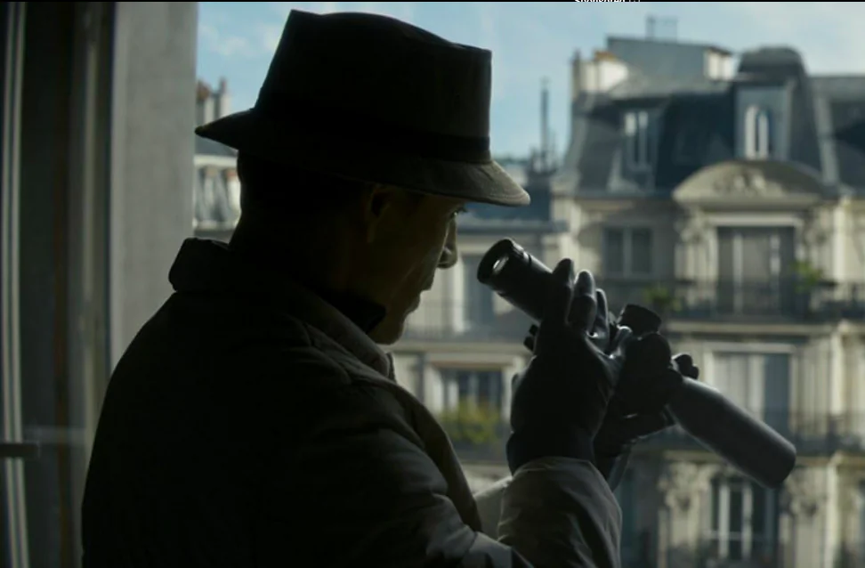 The Killer (MIchael Fassbender) observing a hotel across the street from his sniper-hide, in "The Killer." (Netflix)