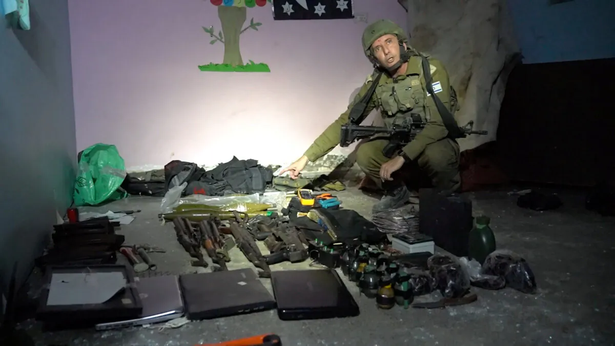 Israeli military spokesperson Rear Admiral Daniel Hagari shows what he says are weapons stored by Hamas terrorists in the basement of Rantissi Hospital, a pediatric hospital with a specialty in treating cancer patients, at a location given as Gaza, in this still image taken from video released on Nov. 13, 2023. (Israel Defense Forces/Handout via Reuters)