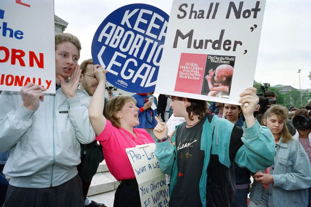 Pro-choice demonstrators (L) and anti-abortion activists (R) face on the steps of the Supreme Court building on April 26, 1989 in Washington, as the court prepares to hear arguements reopening the 1973 landmark abortion case "Roe vs Wade." (Photo by Greg GIBSON / AFP) (Photo by GREG GIBSON/AFP via Getty Images)