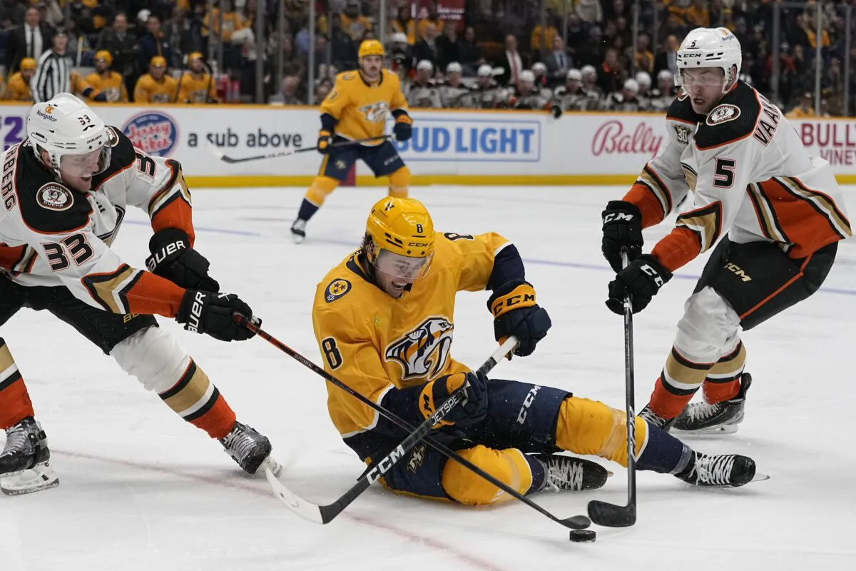 Nashville Predators center Cody Glass (8) battles Anaheim Ducks right wing Jakob Silfverberg (33) and defenseman Urho Vaakanainen (5) for the puck during the second period of an NHL hockey game in Nashville on Nov. 14, 2023. (George Walker IV/AP Photo)