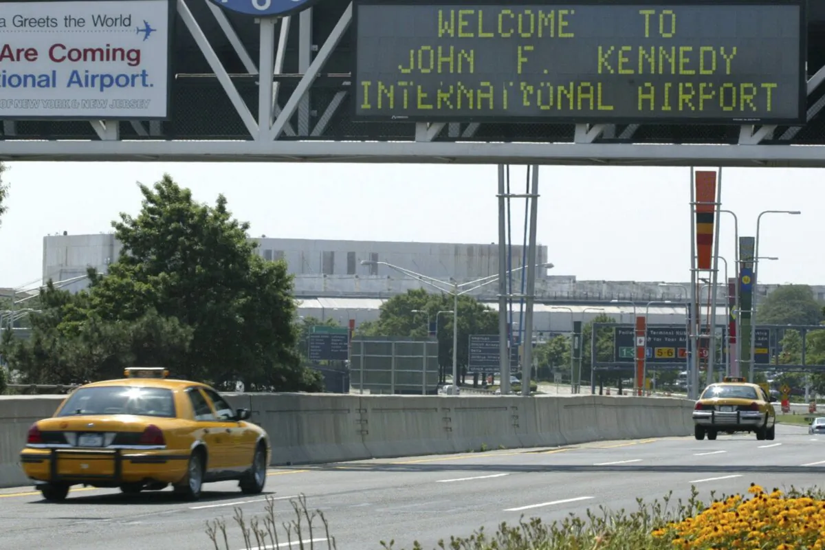 A taxi passes under the entrance to JFK Airport in the New York borough of Queens on Aug. 15, 2003. (Stuart Ramson/AP Photo)