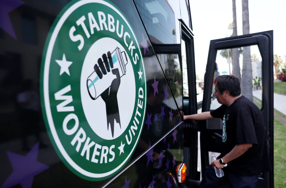 A Starbucks worker boards the Starbucks union bus after workers stood on the picket line with striking actors and writers in solidarity outside Netflix studios in Los Angeles on July 28, 2023. The show of support was part of a Starbucks Workers United summer bus tour in an effort to unionize more Starbucks stores amid a so-called "hot labor summer." (Mario Tama/Getty Images)