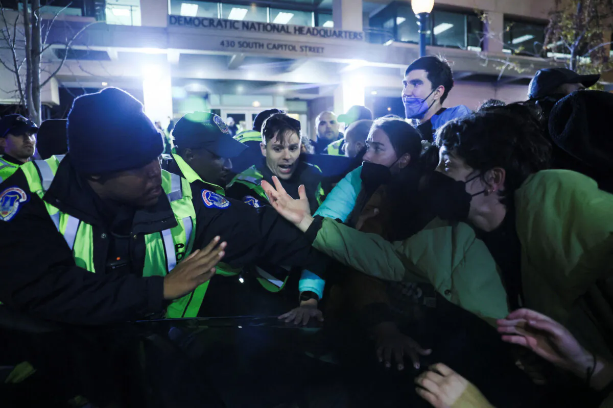 Police and demonstrators argue at the entrance to the Democratic National Headquarters during a multi-denominational event hosted by the Democratic Socialists of America, IfNotNow Movement, and Jewish Voice for Peace calling for a ceasefire in the conflict between Israel and Palestinian terrorist group Hamas, in Washington, on Nov. 15, 2023. (Leah Millis/Reuters)