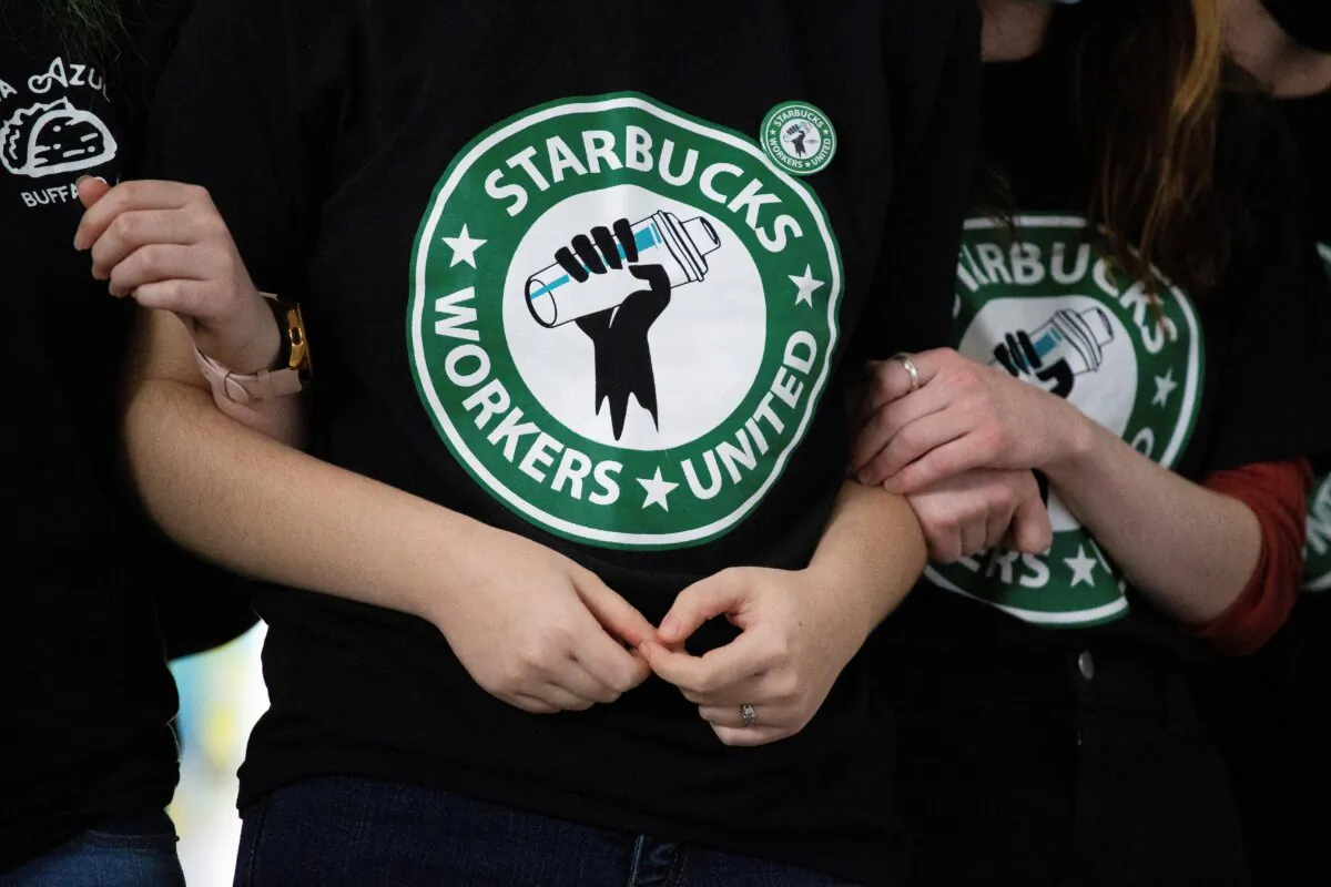 Starbucks employees and supporters link arms during a union election watch party in Buffalo, N.Y., on Dec. 9, 2021. (Joshua Bessex/AP Photo)