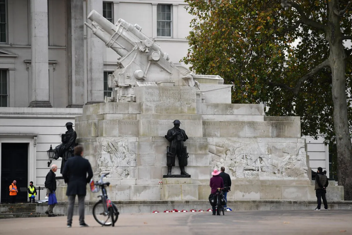 People stand to observe a two minute silence to commemorate Armistice Day at the Royal Artillery Memorial in London on Nov. 11, 2020. (Ben Stansall/AFP)