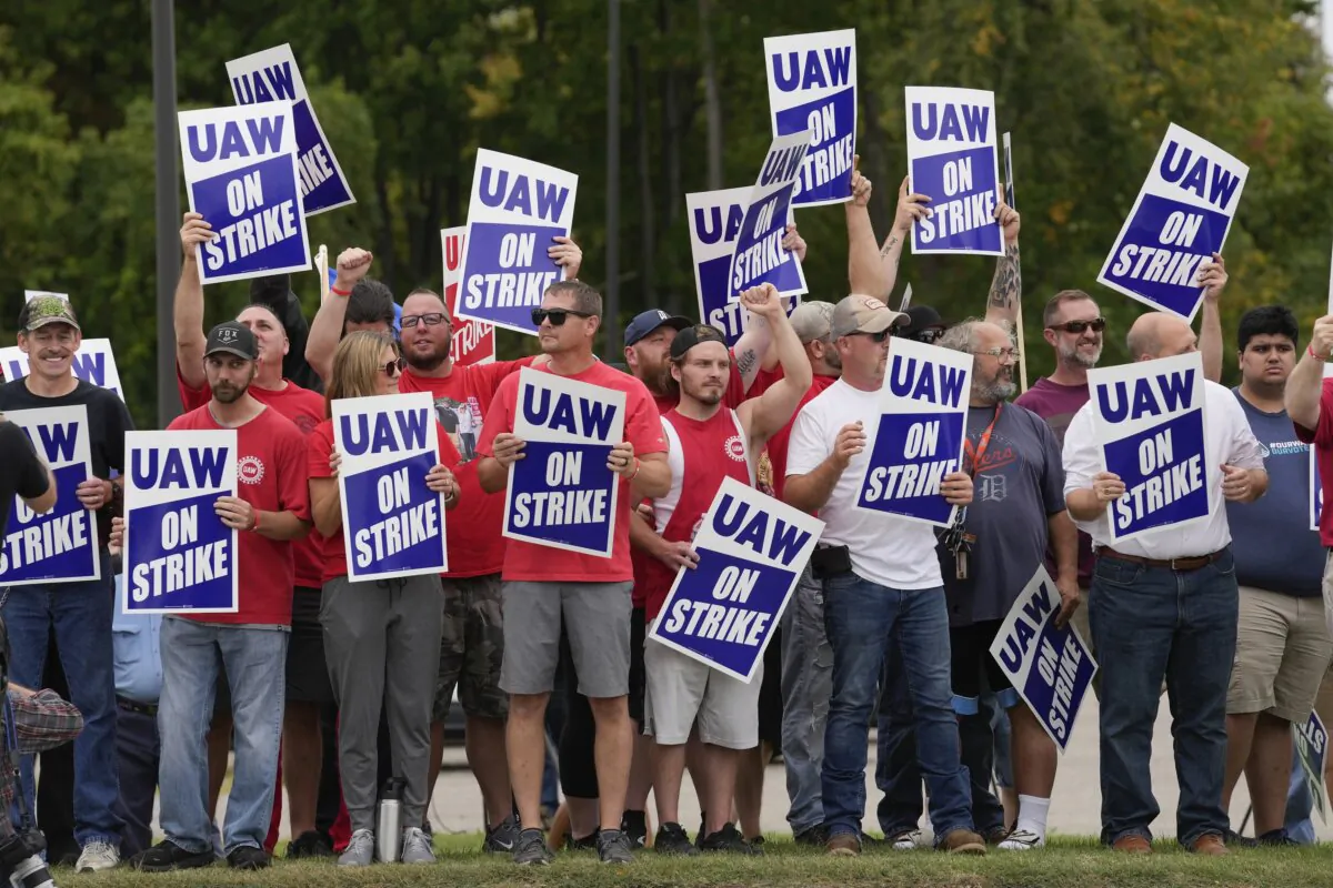 United Auto Workers members hold picket signs near a General Motors assembly plant in Delta Township, Mich., on Sept. 29, 2023. (Paul Sancya/AP Photo)