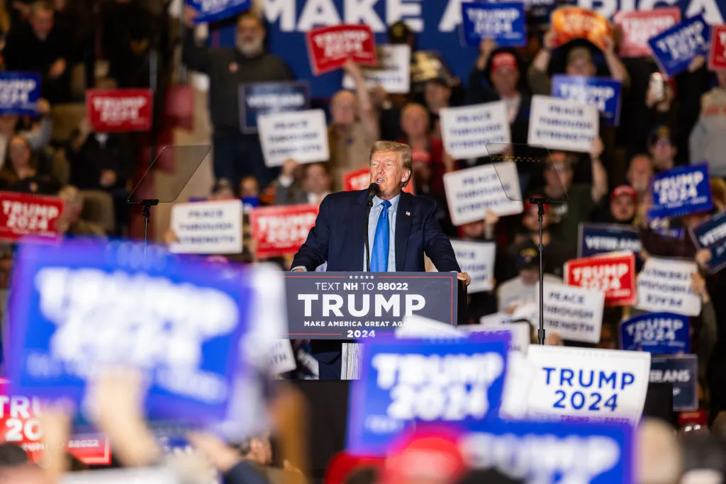 A supporter of Republican front-runner former President Donald Trump hold up signs while he delivers remarks during a campaign event in Claremont, N.H., on Nov. 11, 2023. (Scott Eisen/Getty Images)