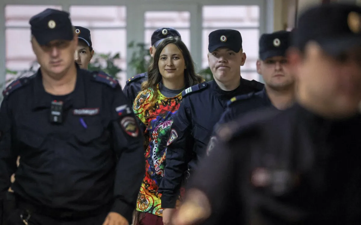 Artist Alexandra (Sasha) Skochilenko, who is charged with spreading false information about Russia's armed forces by means of replacing supermarket price tags with slogans protesting against the country's military campaign in Ukraine, is escorted by police officers before a court hearing in Saint Petersburg, Russia, on Nov. 14, 2023. (Anton Vaganov/Reuters)