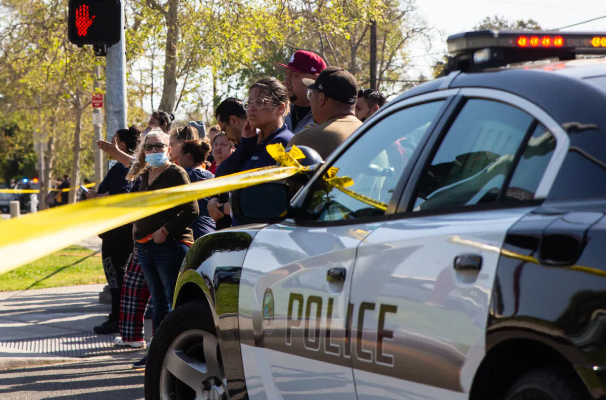 Police officers respond to a school threat while families gather behind police tape in Santa Ana, Calif., on March 10, 2022. (John Fredricks/The Epoch Times)