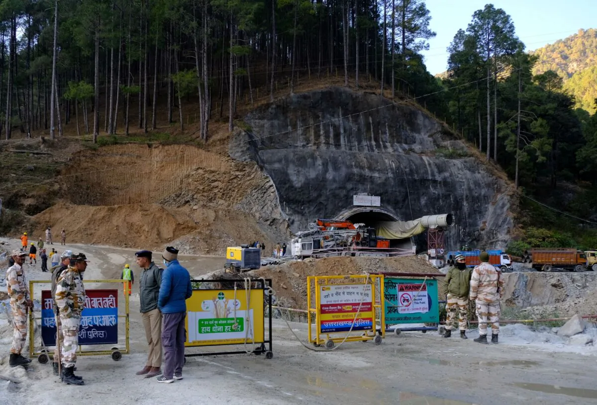 Police officers stand guard next to a barricade past the entrance of a tunnel where 40 road workers are trapped after a portion of the tunnel collapsed in Uttarkashi in the northern state of Uttarakhand, India, on Nov. 16, 2023. (Shankar Prasad Nautiyal/Reuters)