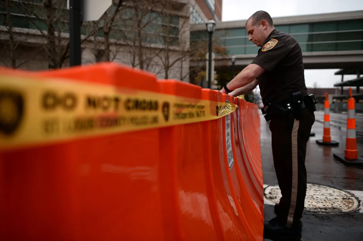 A police officer puts "do not cross" tape on barricades around the Buzz Westfall Justice Center in Clayton, Mo., on Nov. 23, 2014. (Jewel Samad/AFP via Getty Images)