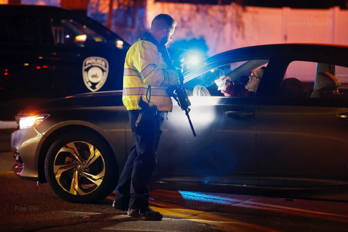 A police officer manning a roadblock talks with an employee of New Hampshire Hospital who was trying to get to work, in Concord, N.H., on Nov. 17, 2023. (Michael Dwyer/AP Photo)