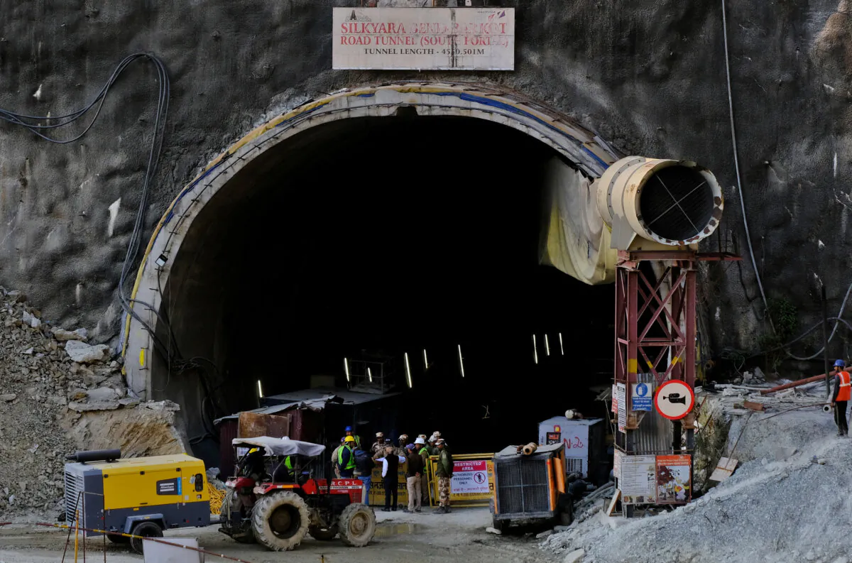 Members of rescue teams stand at the entrance of a tunnel where road workers are trapped after a portion of the tunnel collapsed in Uttarkashi in the northern state of Uttarakhand, India, on Nov. 17, 2023. (Shankar Prasad Nautiyal/Reuters)