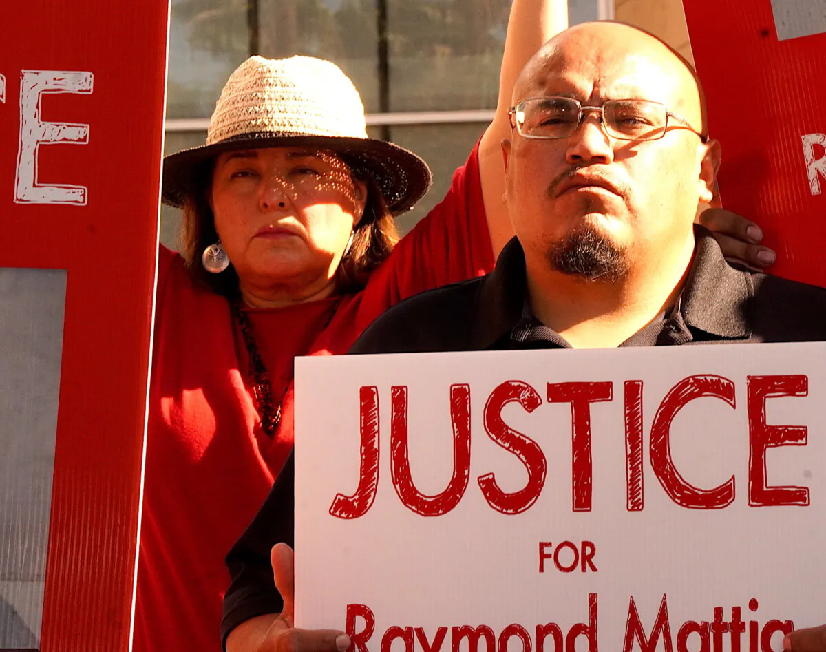 A man holds a sign in support of the late Ray Mattia, a member of Arizona's Tohono O'odham Nation, in front of the federal court in Tucson, Ariz., on Nov. 17, 2023. (Allan Stein/The Epoch Times)