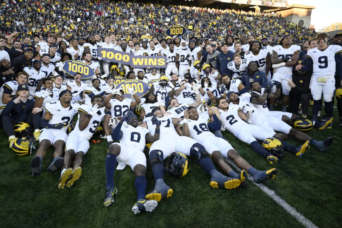 Michigan poses for photographers after an NCAA college football game that earned them their 1,000 win in school history, in College Park, Md., on Nov. 18, 2023. (Nick Wass/AP Photo)