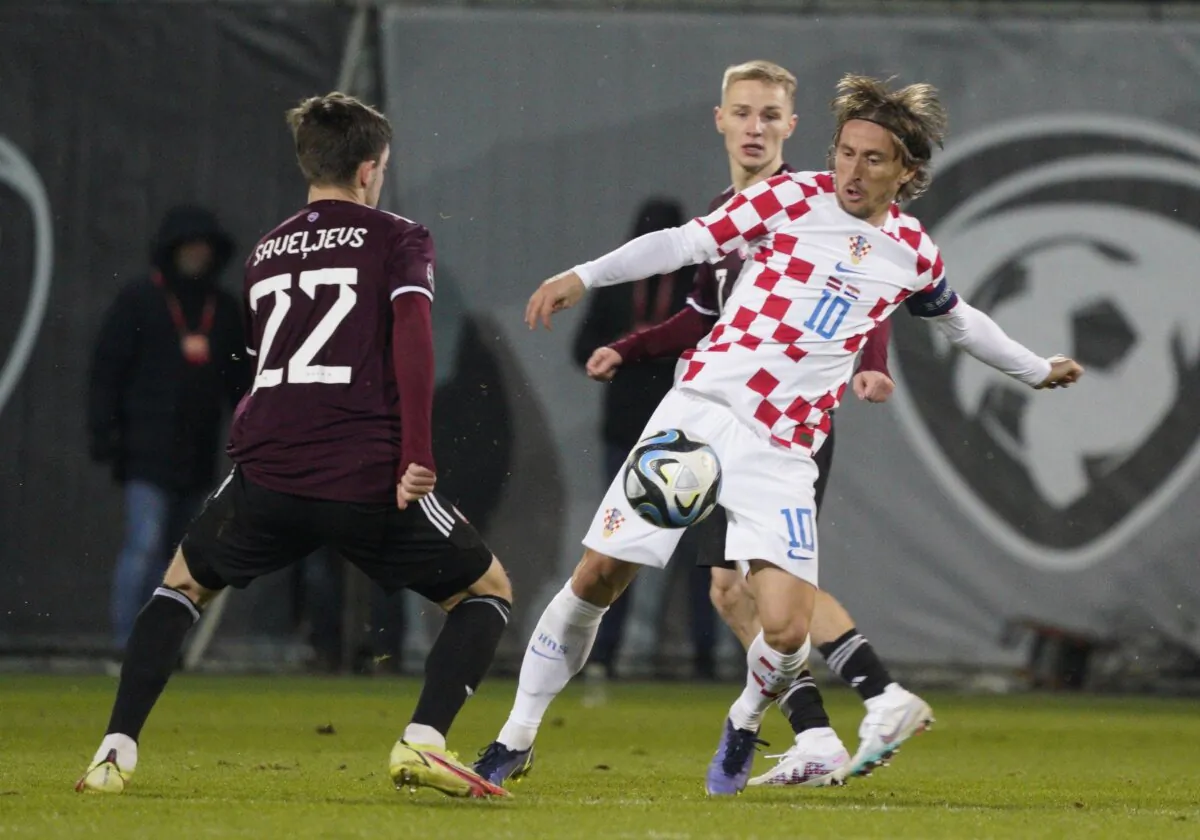 Croatia's Luka Modric (R) challenges for the ball with Latvia's Aleksejs Saveljevs (L) during the Euro 2024 group D qualifying soccer match between Latvia and Croatia in Riga, Latvia, on Nov. 18, 2023. (Roman Koksarov/AP Photo)