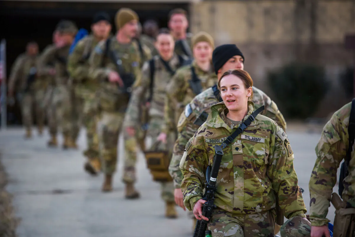 Soldiers with the 82nd Airborne division walk across the tarmac at Green Ramp to deploy to Poland, at Fort Bragg, Fayetteville, N.C., on Feb. 14, 2022. (Melissa Sue Gerrits/Getty Images)