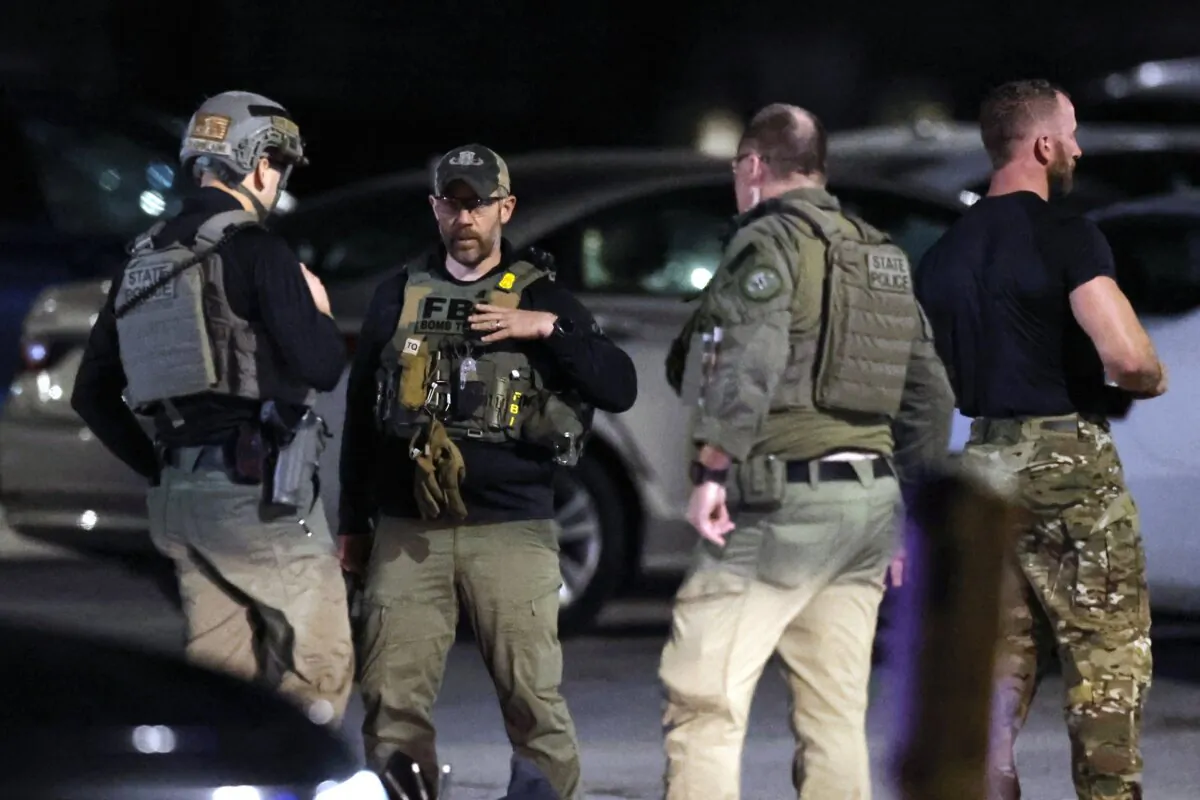 State police and an FBI bomb technician stand at a staging area in the parking lot of New Hampshire Hospital in Concord, N.H., on Nov. 17, 2023. (Michael Dwyer/AP Photo)