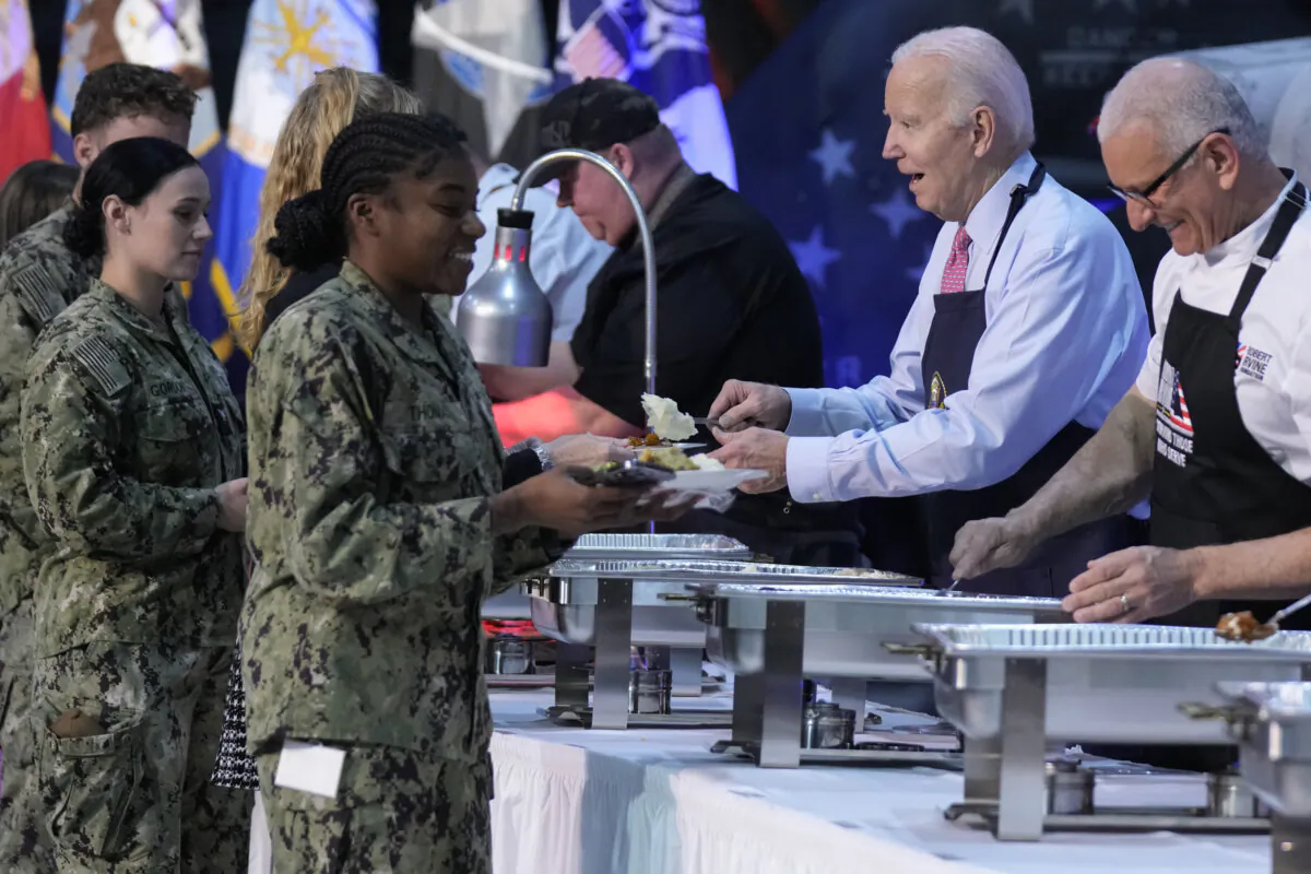 President Joe Biden and chef Robert Irvine (R) help serve a "friendsgiving" meal to service members and their relatives at the Norfolk Naval Station in Norfolk, Va., on Nov. 19, 2023. (Manuel Balce Ceneta/AP Photo)
