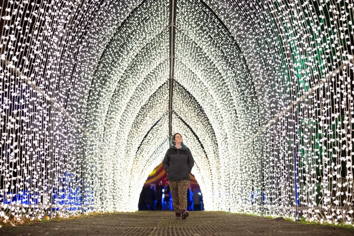 National Trust employee Victoria Emms experiences an artwork entitled Cathedral on the Christmas at Dunham Massey festive light art trail at the National Trust property near Altrincham, northeast England, on Nov. 16, 2023. (Oli Scarff/AFP via Getty Images)