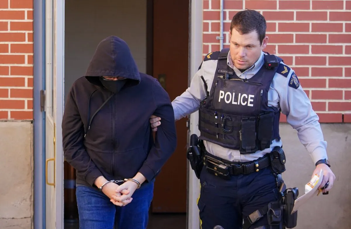 Michael MacKay (L) was escorted out of Battleford Courthouse by a RCMP officer after being convicted of second-degree murder of his wife Cindy MacKay in Battleford, Sask., on Nov. 20, 2023. (The Canadian Press/Heywood Yu)