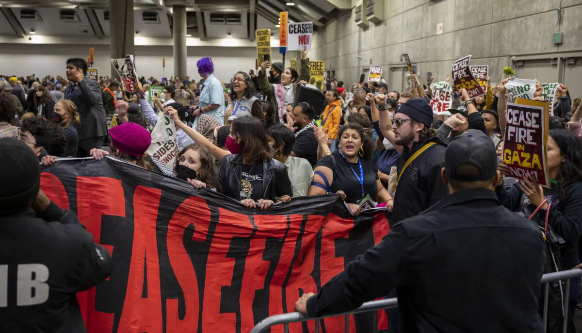 Pro-Palestinian demonstrators enter the convention hall during the afternoon session of the 2023 California Democratic Party November State Endorsing Convention at SAFE Credit Union Convention Center in Sacramento, Calif., on Nov. 18, 2023. (Lezlie Sterling/The Sacramento Bee via AP)