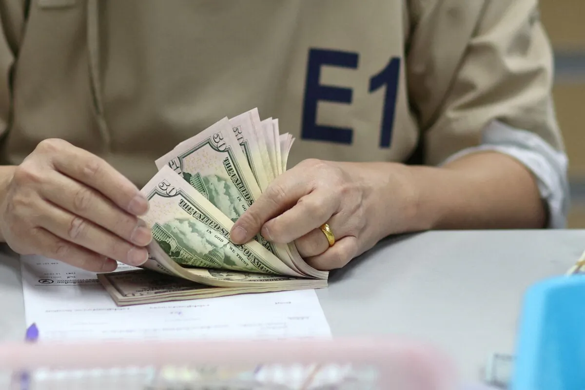 A bank employee counts U.S. dollar notes at a Kasikornbank in Bangkok, Thailand, on Jan. 26, 2023. (Athit Perawongmetha/Reuters)