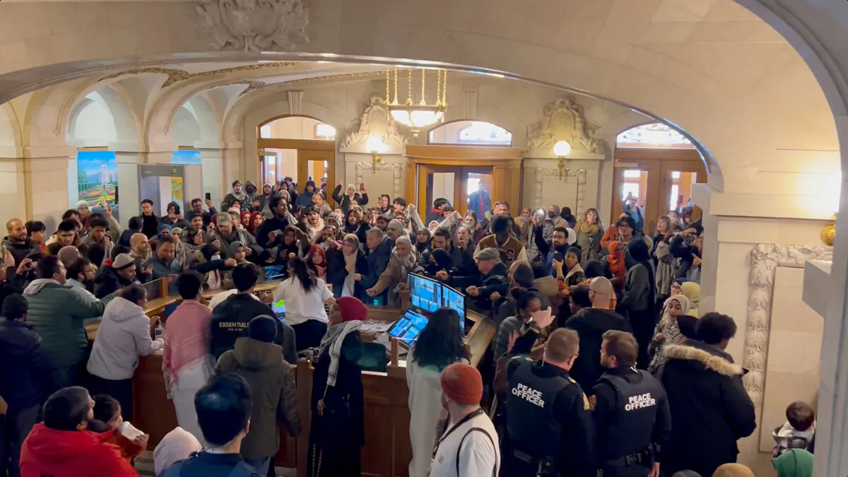 Dozens of protesters fill the entrance to the Saskatchewan Legislature in Regina on Nov. 20, 2023, calling for a ceasefire in Gaza and disrupting the legislature. (The Canadian Press/Jeremy Simes)