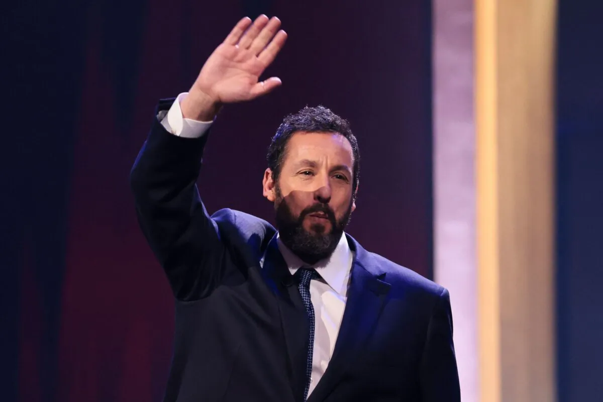 Actor Adam Sandler waves as he steps on stage during the 24th Annual Mark Twain Prize For American Humor at the John F. Kennedy Center for the Performing Arts in Washington on March 19, 2023. (Oliver Contreras/AFP via Getty Images)