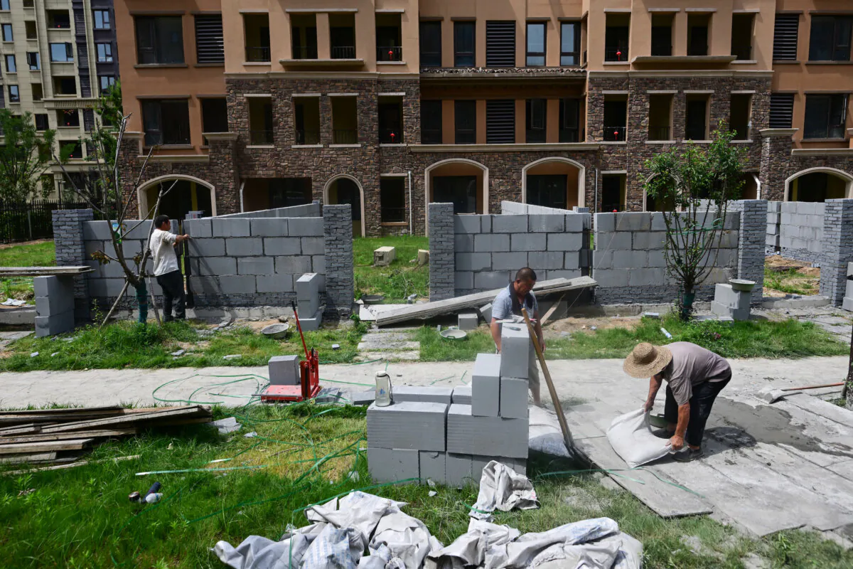 Men working at a complex of unfinished apartment buildings in Xinzheng City, China, on June 20, 2023. (Pedro Pardo/AFP/Getty Images)