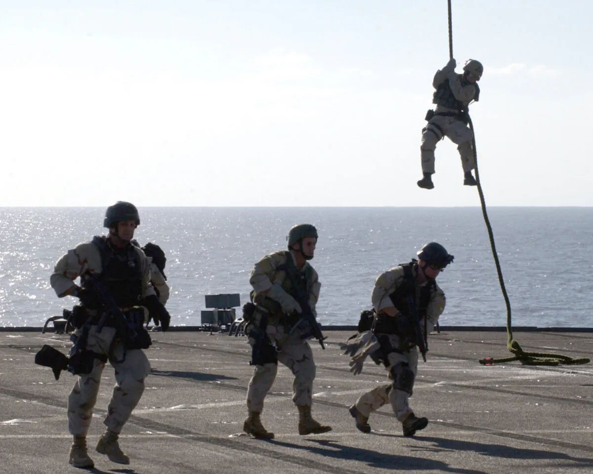 U.S. Navy SEALs (SEa, Air, and Land) fast-rope on the deck of the amphibious command ship USS Mount Whitney during a training exercise January 17, 2003 while at sea. (George R. Kusner/U.S. Navy/Getty Images)