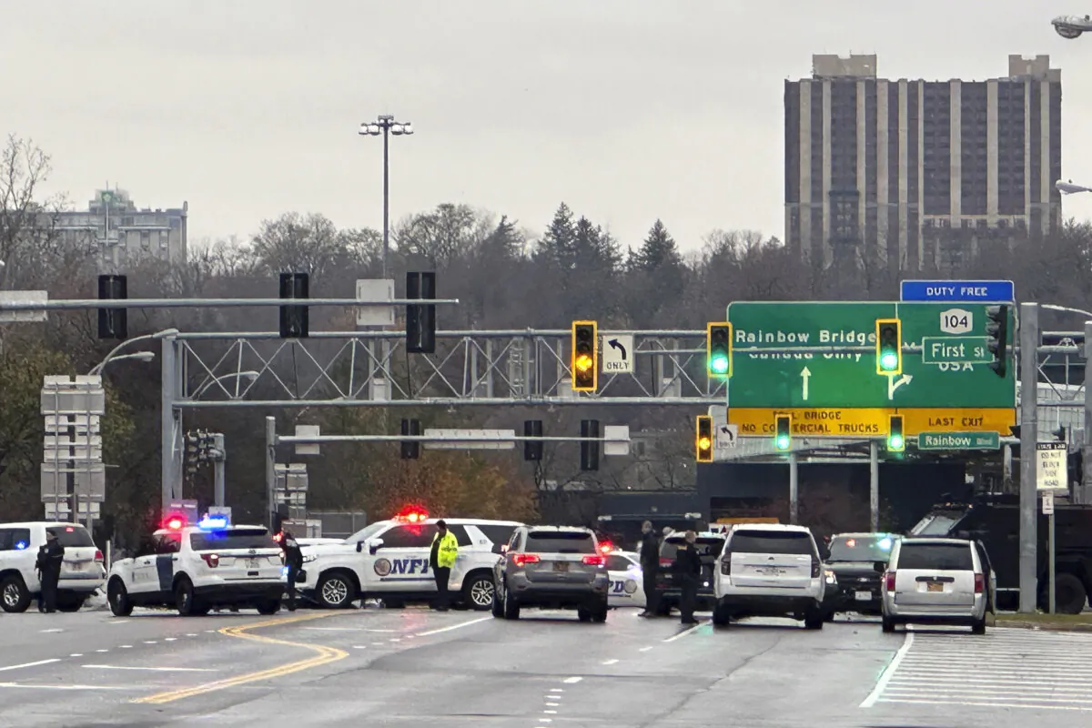 Law enforcement personnel block off the entrance to the Rainbow Bridge border crossing in Niagara Falls, N.Y., on Nov. 22, 2023. The border crossing between the U.S. and Canada has been closed after a vehicle exploded at a checkpoint on a bridge near Niagara Falls. (AP Photo/Carolyn Thompson)