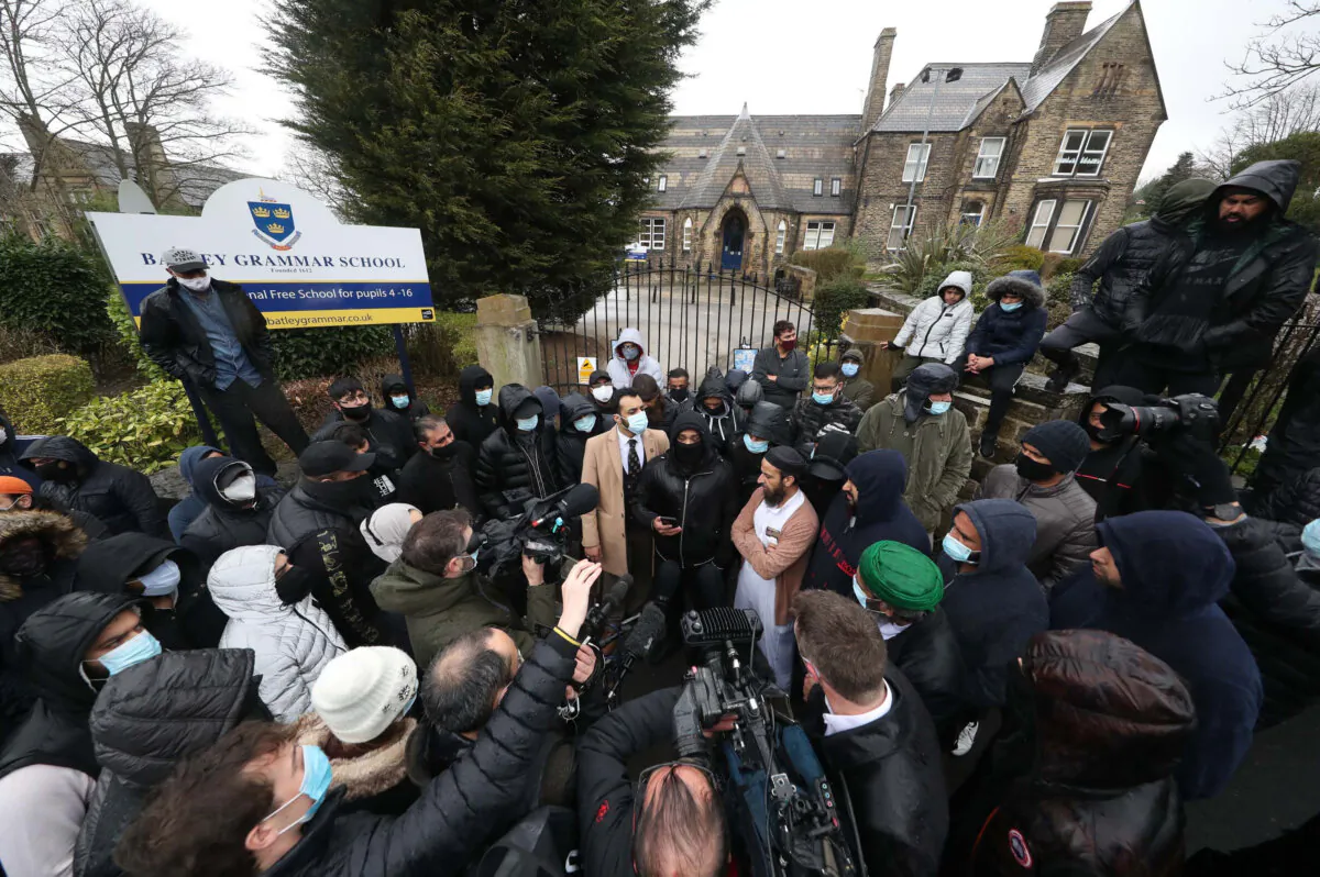 Protesters give a statement to members of the media outside Batley Grammar School in Batley, West Yorkshire, where a teacher has been suspended for showing a caricature of the Prophet Muhammad to pupils during a religious studies lesson, on March 26, 2021. (PA Media) 