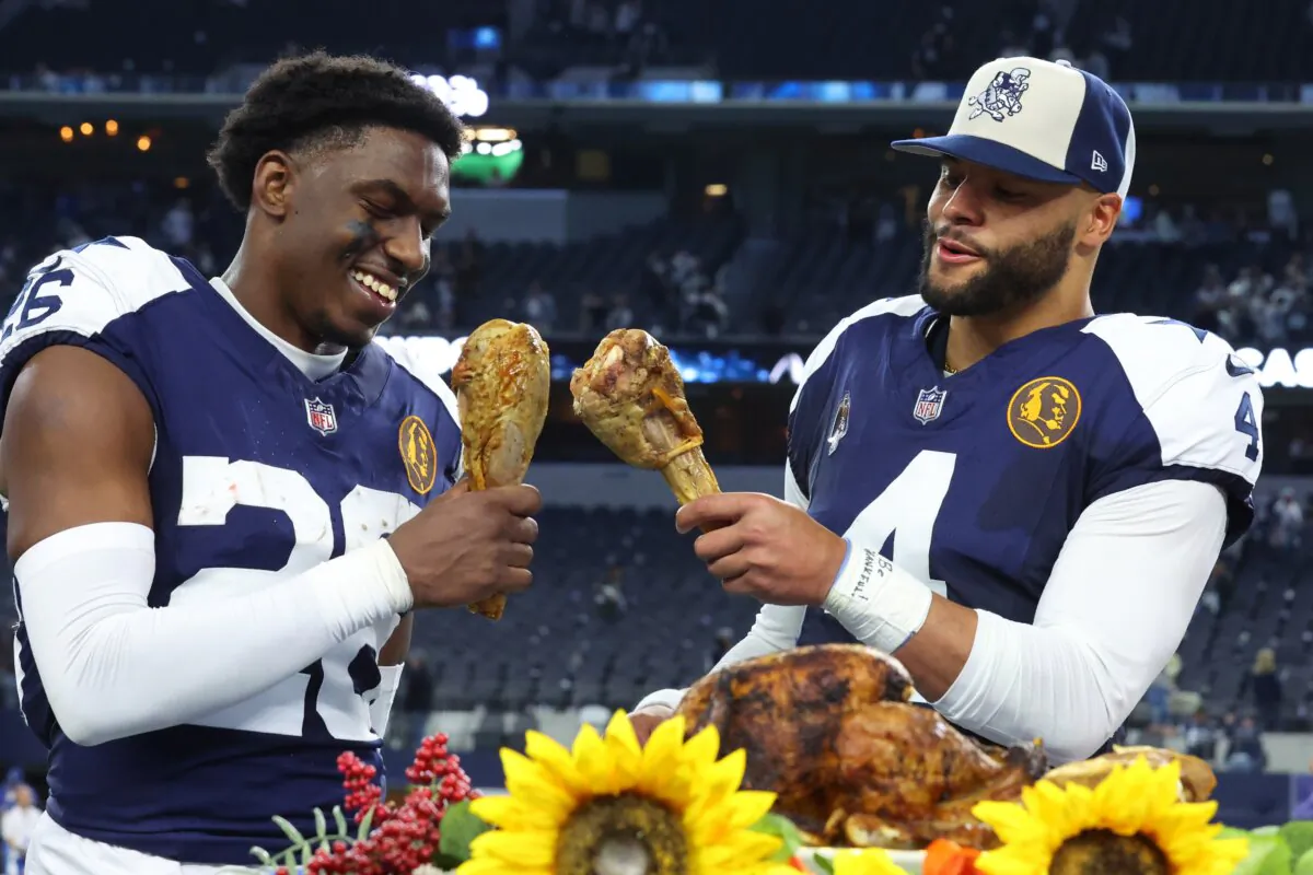 DaRon Bland (26) Dak Prescott (4) of the Dallas Cowboys take a bite out of a turkey leg after a win over the Washington Commanders in Arlington, Texas, on Nov. 23, 2023. (Richard Rodriguez/Getty Images)