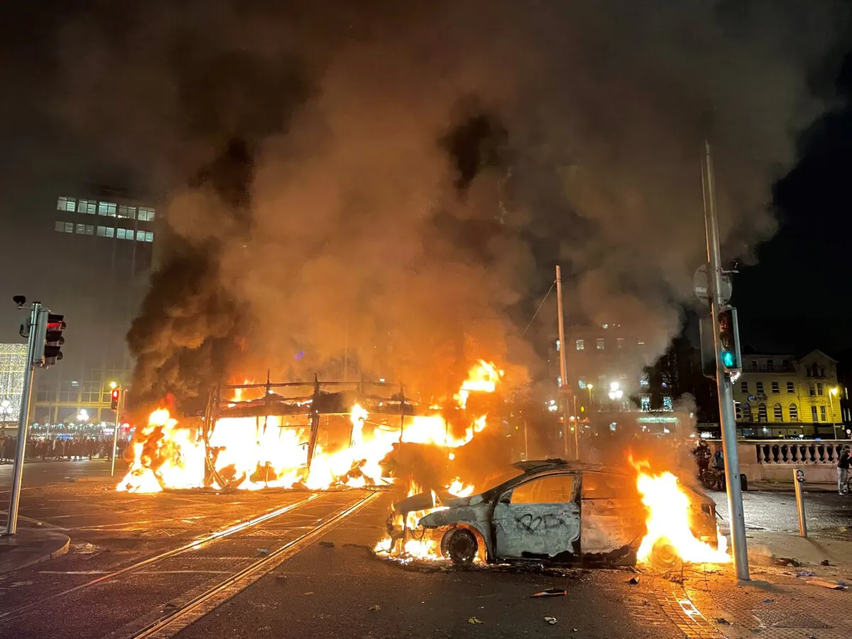 A bus and car on fire on O'Connell Street in Dublin city centre after violent scenes unfolded following an attack on Parnell Square East where five people were injured, including three young children, on Nov. 23, 2023. (Brian Lawless/PA Wire)