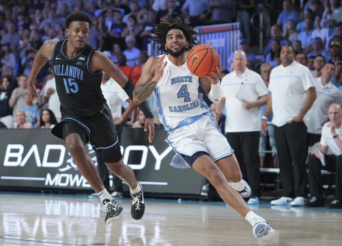 North Carolina's RJ Davis drives to the basket with Villanova's Jordan Longino close behind during overtime in an NCAA college basketball game in the Battle 4 Atlantis at Paradise Island, Bahamas, on Nov. 23, 2023. (Ronnie Archer/Bahamas Visual Services via AP)