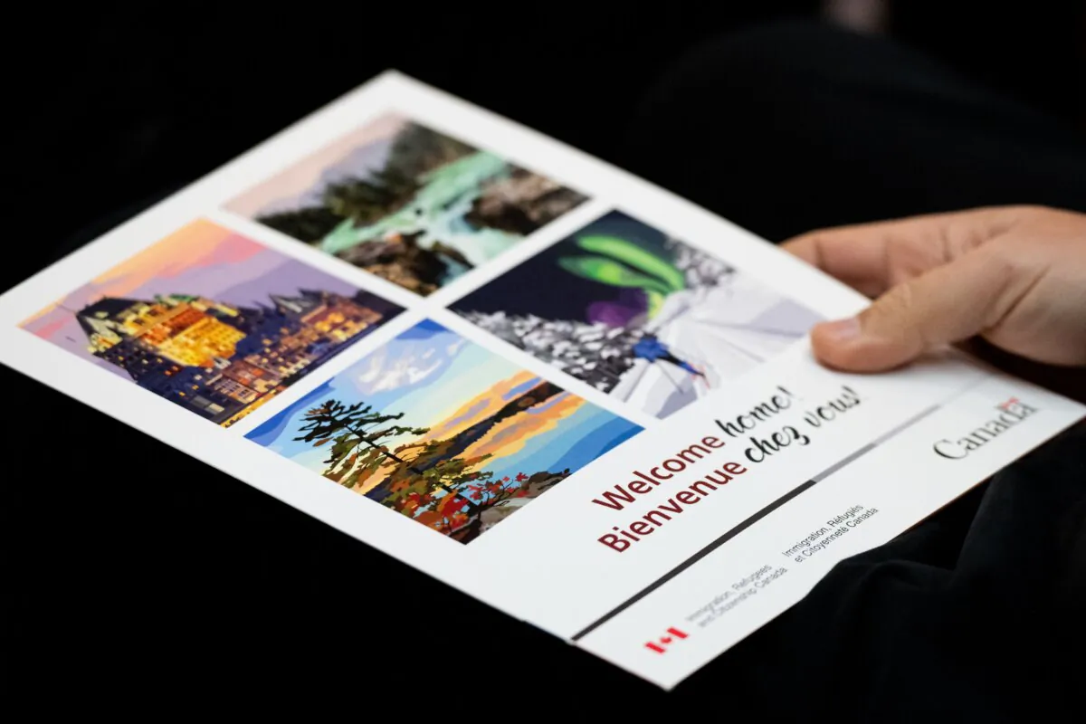 A new Canadian citizen holds a welcome booklet during a Canadian citizenship ceremony in Ottawa on Nov. 22, 2023. (The Canadian Press/Spencer Colby)