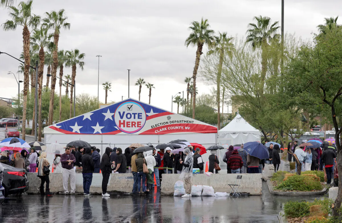 People line up in the rain to vote at a tent in a shopping center parking lot in Las Vegas, Nev., on Nov. 8, 2022. (Ethan Miller/Getty Images)
