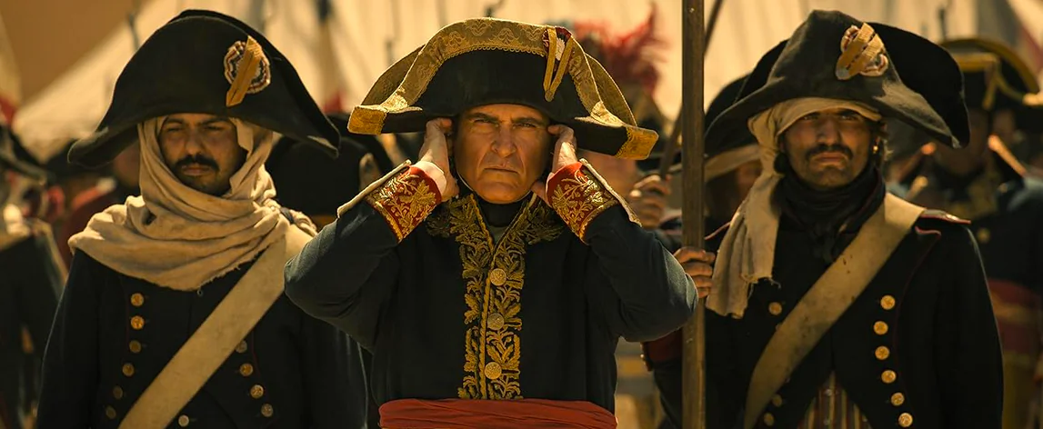 Napoleon Bonaparte (Joaquin Phoenix, center) covers his ears during canon fire, in "Napoleon." (Aidan Monaghan/Apple)