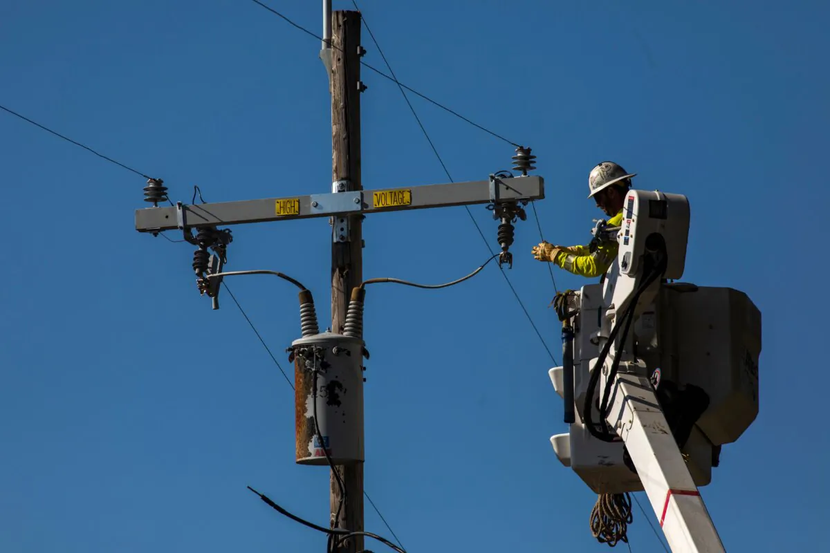 A PG&E contractor works on utility poles along Highway 128 near Geyserville, Calif., on Oct. 31, 2019. (Philip Pacheco/AFP via Getty Images)