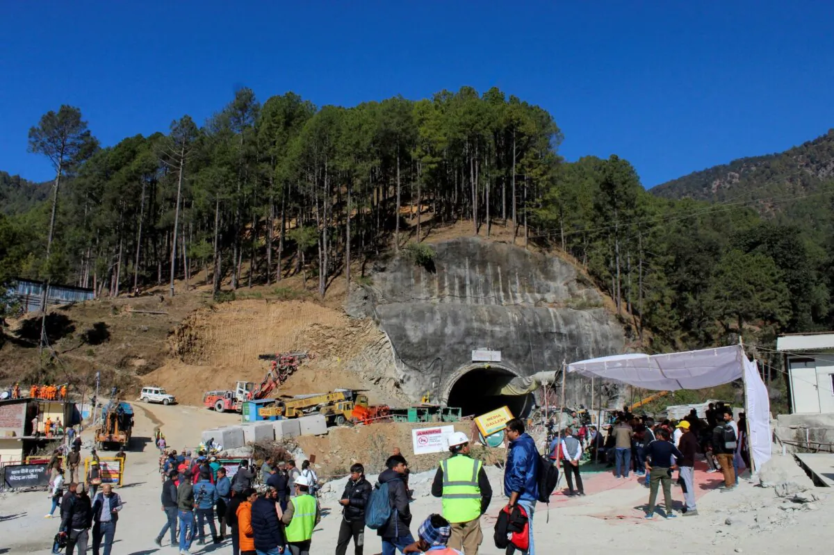 Media personnel and onlookers gather near the entrance of a tunnel under construction where workers are trapped following a collapse, in Uttarkashi, in the northern state of Uttarakhand, India, on Nov. 24, 2023. (Stringer/Reuters)