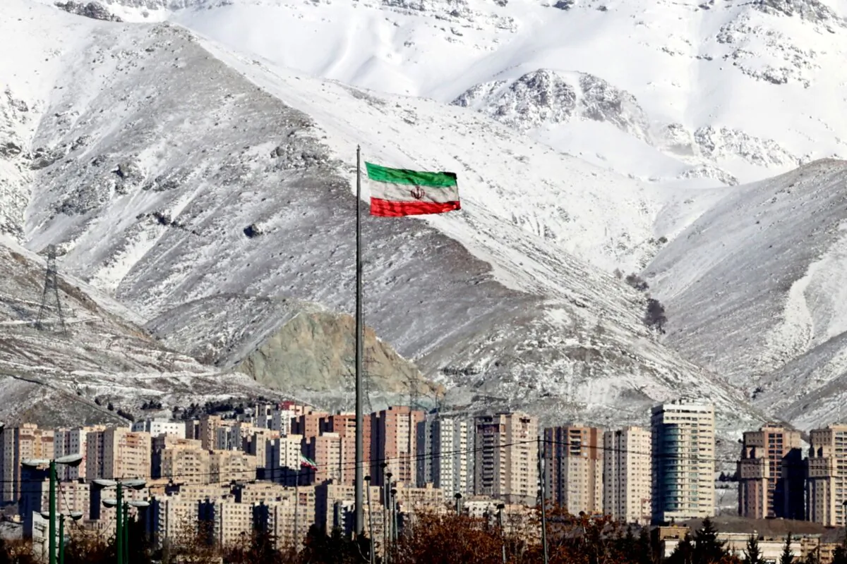 A view shows the the Iranian flag in capital Tehran with the snow-covered Alborz mountain range in the background on Jan. 18, 2022. (Atta Kenare/AFP via Getty Images)