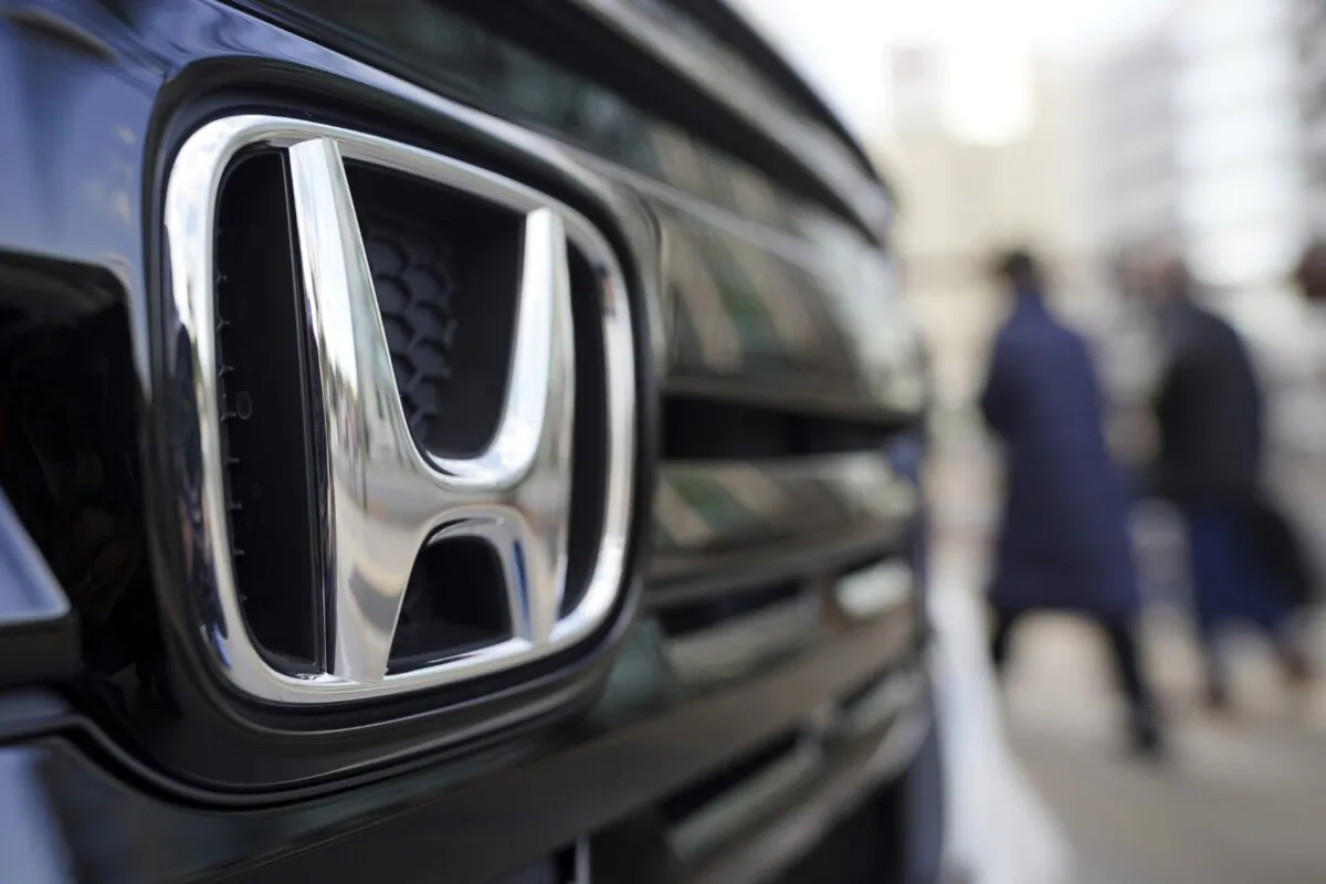 People walk near the logo of Honda Motor Company at a showroom in Tokyo on Feb. 8, 2022. (Eugene Hoshiko/AP Photo)