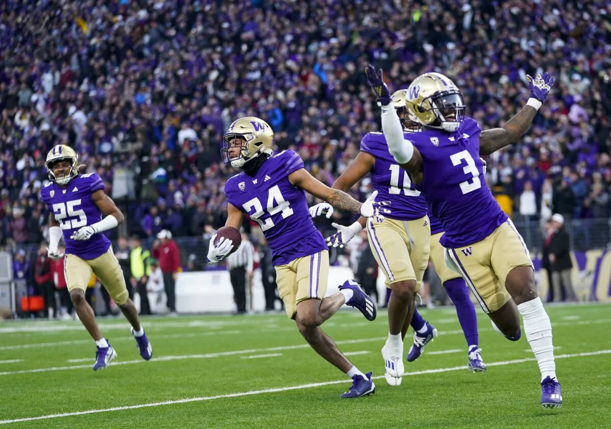 Washington safety Makell Esteen (24) runs with safety Mishael Powell (3) after making an interception against Washington State during the second half of an NCAA college football game in Seattle on Nov. 25, 2023. (Lindsey Wasson/AP Photo)
