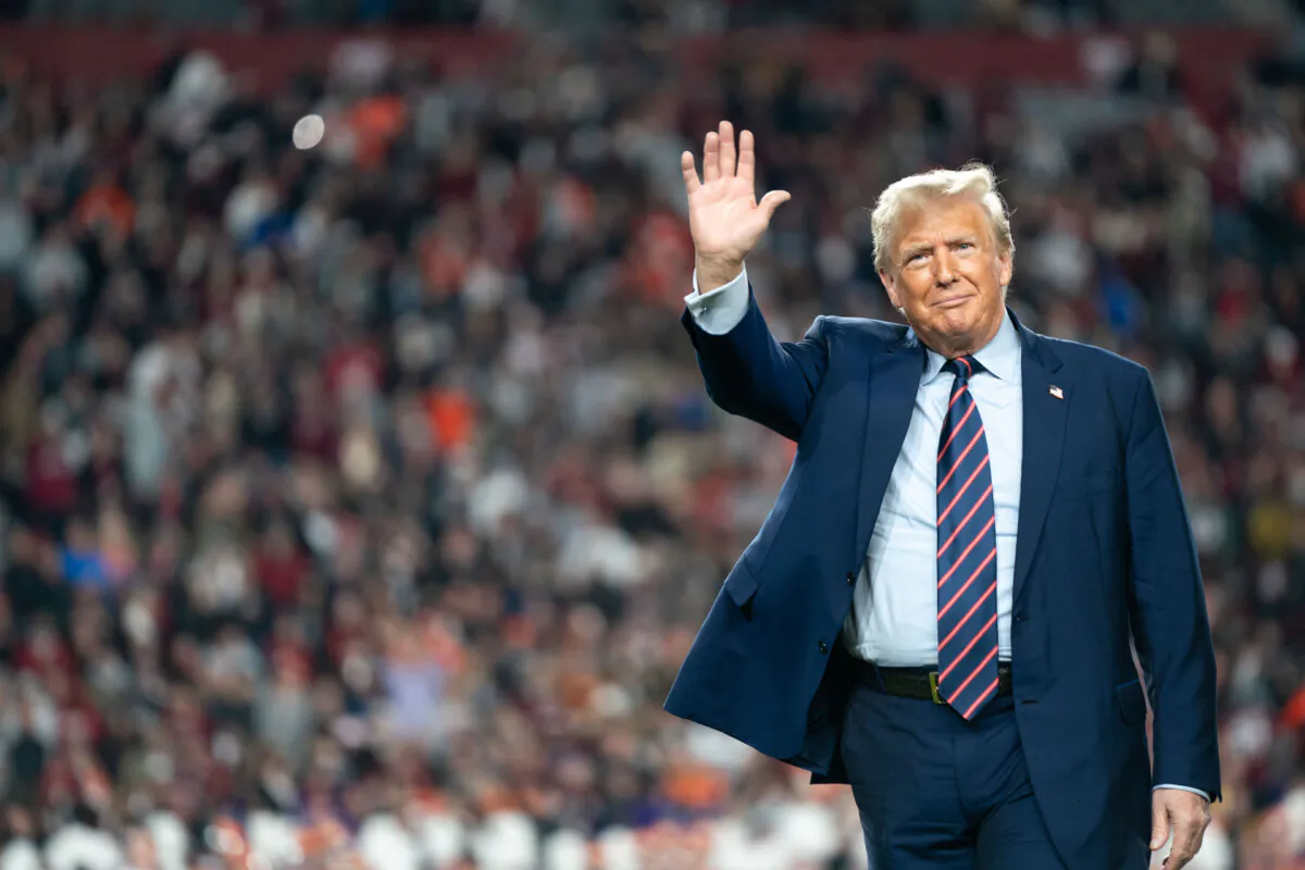 Former President Donald Trump waves to football fans on the field during halftime in the Palmetto Bowl between Clemson and South Carolina at Williams Brice Stadium in Columbia, S.C., on Nov. 25, 2023. (Sean Rayford/Getty Images)