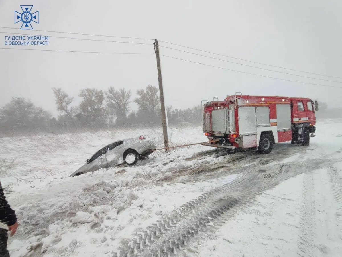 Emergency workers release a car which is stuck in snow during a heavy snow storm in Odesa region, Ukraine, in a handout picture released on Nov. 27, 2023. (Press service of the State Emergency Service of Ukraine in Odesa region/Handout via Reuters)