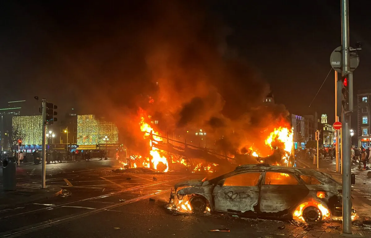 Flames rise from a car and a bus at the junction of Bachelors Walk and O'Connell Bridge in Dublin, Ireland, on Nov. 23, 2023, as people rioted following the stabbing of three children earlier in the day.  (Peter Murphy/AFP via Getty Images)