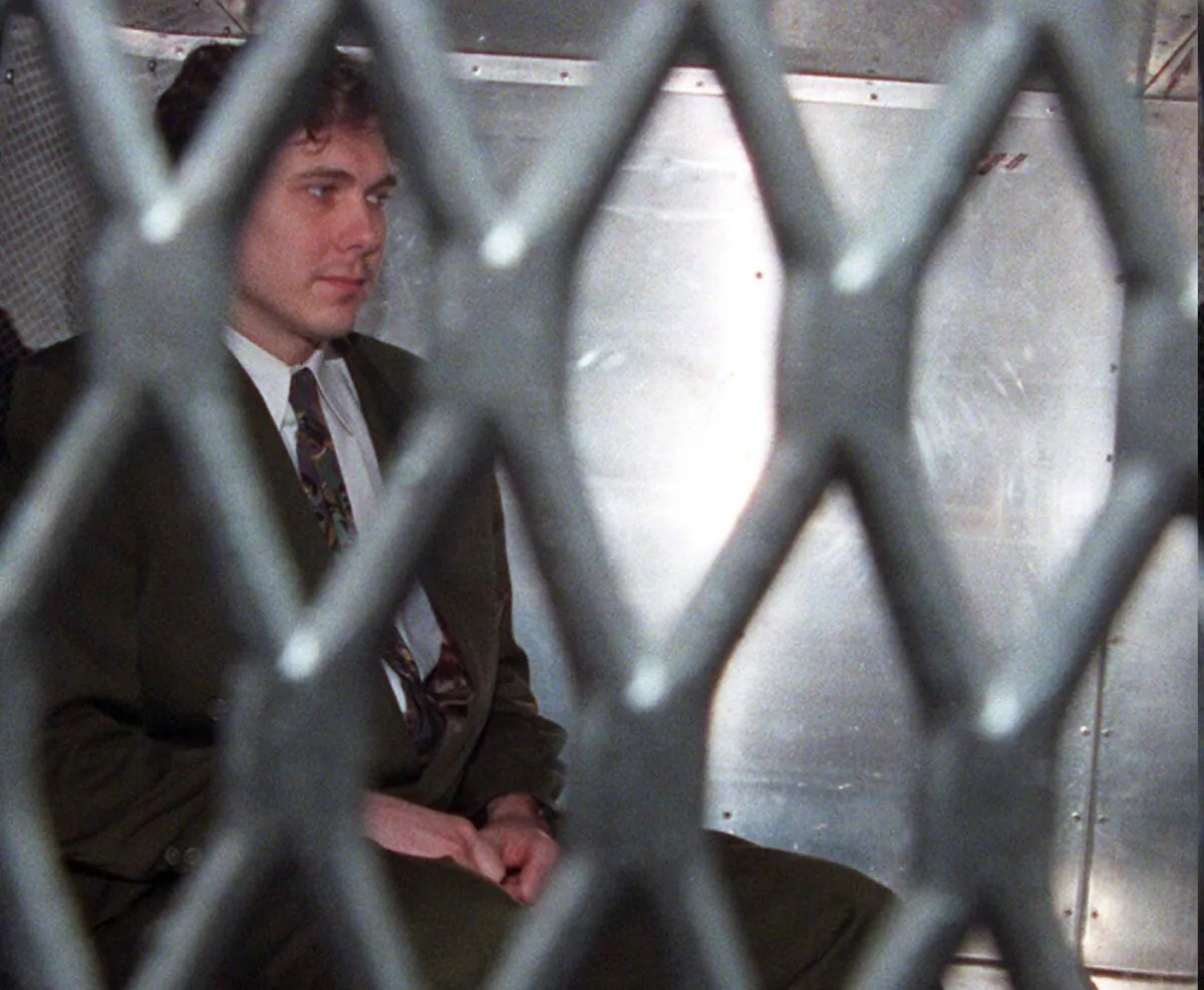 Paul Bernardo arrives at the provincial courthouse in the back of a police van in Toronto in a file photo on Nov. 3, 1995. (The Canadian Press/Frank Gunn)