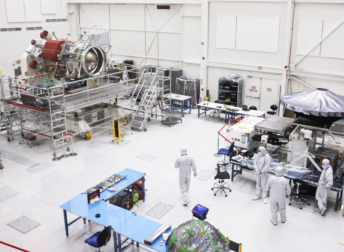 Employees gather near a propulsion component (L) for the Europa Clipper spacecraft at the Spacecraft Assembly Facility clean room at NASA's Jet Propulsion Laboratory in Pasadena, Calif., on April 11, 2023. (Mario Tama/Getty Images)